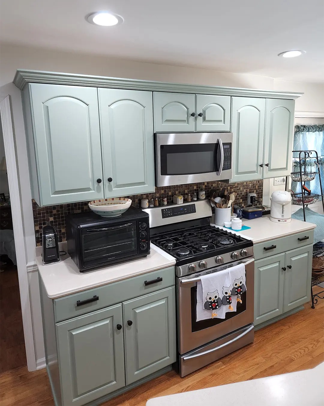 Kitchen cabinets refinished in a soft sage green