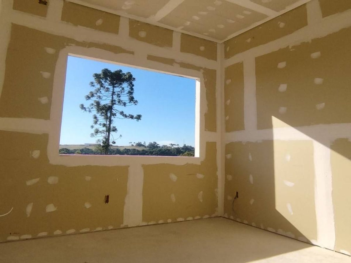 Interior room under drywall installation with taped seams and a bright window
